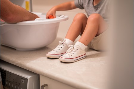 little boy sitting on the counter helping wash dishes in arlington wa