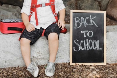 back to school chalkboard next to a boy sitting on the curb in Arlington WA